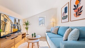 A modern living room with a television, sofa, coffee table, and artwork. - Rooftop Apartment with Private Terrace (Lisboa)