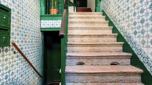 A staircase with green railings and patterned walls. - Rooftop Apartment with Private Terrace (Lisboa)