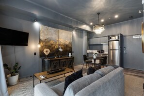 Ein modernes Wohnzimmer mit Sofa, Couchtisch und Kunstwerk an der Wand.