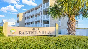 Un edificio de varios pisos con un letrero que dice 'RAINTREE VILLAS 4800'.