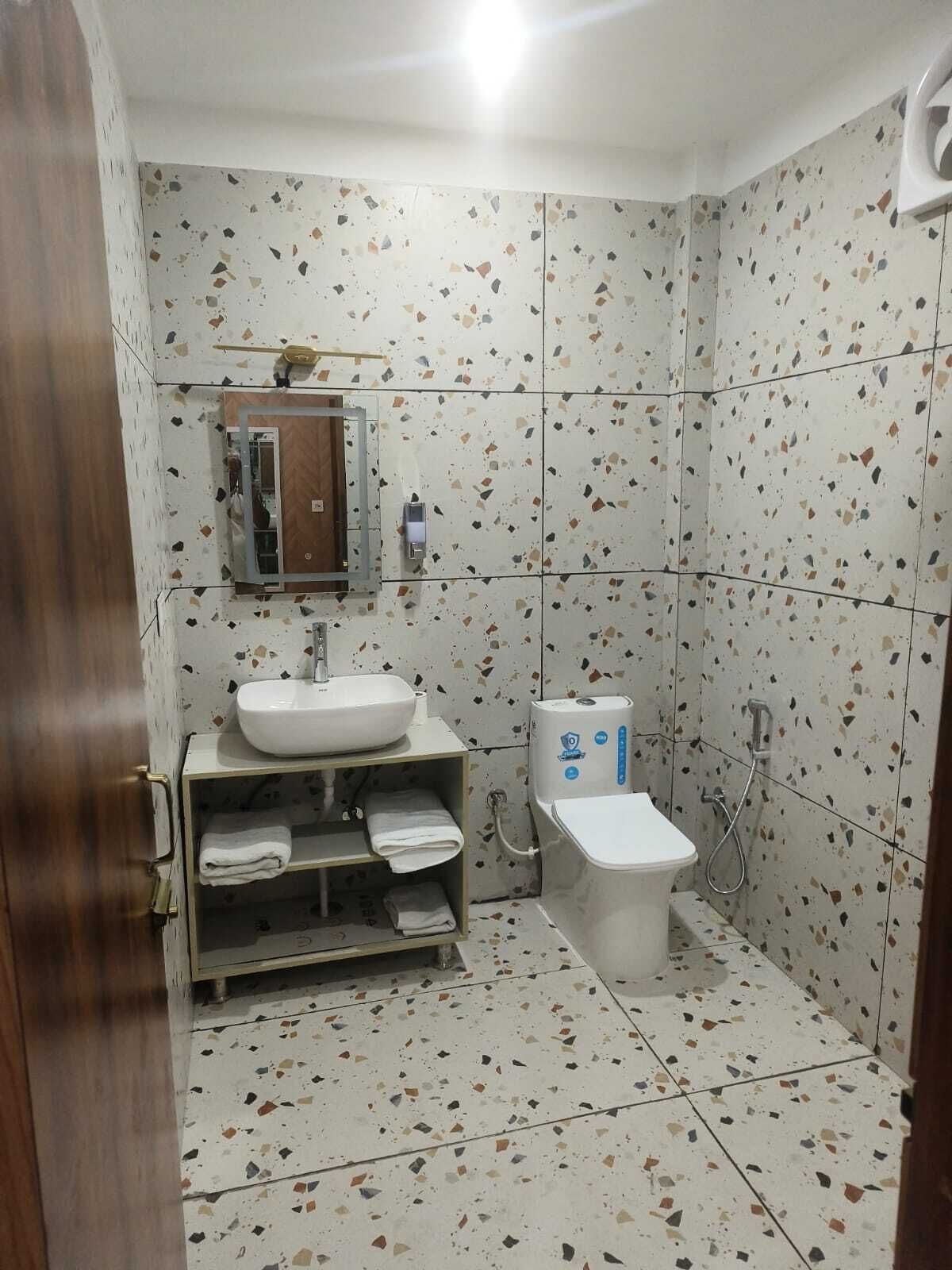A bathroom with a white sink, a toilet, and a shower.