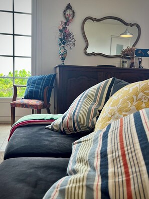 A bedroom with a large window, a wooden dresser, a mirror, and a chair. - Family vacation home facing the beach on the edge of the GR34 (Porspoder)