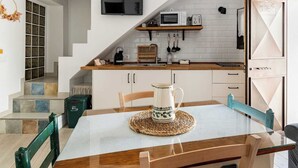 Een moderne keuken met een televisie, magnetron en broodrooster op een houten plank.