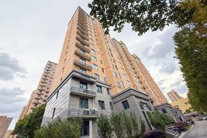Un palazzo residenziale di grandi dimensioni con numerosi balconi, un design architettonico moderno e un contesto urbano circostante.