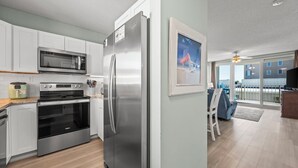 Una cocina moderna con electrodomésticos de acero inoxidable, microondas, horno y refrigerador.