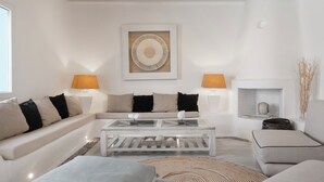 A modern living room with a white sofa, a coffee table, and two lamps. - Patron 1 Pool Sunset Villa- Seven Bedrooms (Mikonos)