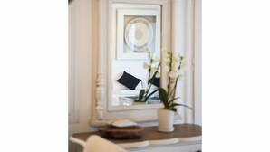 A room with a white-framed mirror, a framed picture, and a potted plant on a table. - Patron 1 Pool Sunset Villa- Seven Bedrooms (Mikonos)