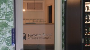 A room with a glass door, a refrigerator, and a wall with a tropical leaf pattern. - Favorite Room&Spa (San Giuseppe Vesuviano)