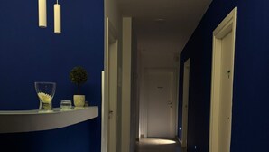A hallway with blue walls, white doors, and a tiled floor. - Favorite Room&Spa (San Giuseppe Vesuviano)