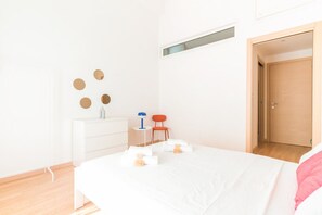 A bedroom with a bed, a dresser, a chair, and a door. - Gloria s Nest 5 Minutes to Porta Romana (Milan)