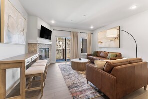 Ein modernes Wohnzimmer mit einer Couch, einem Couchtisch, einem Fernseher und Kunstwerken.