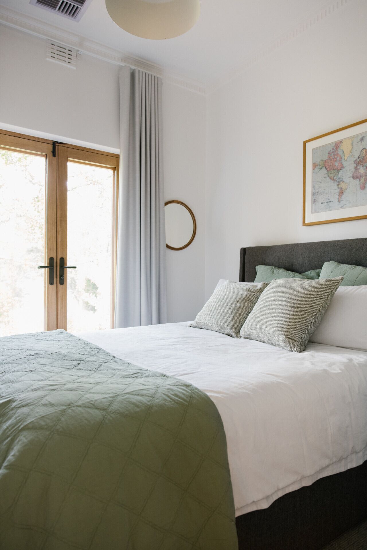 Une chambre à coucher comprenant un lit, une fenêtre, un globe terrestre fixé au mur et un élément de décoration circulaire.