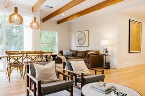 A spacious living room with a wooden dining table, two sofas, and a coffee table.