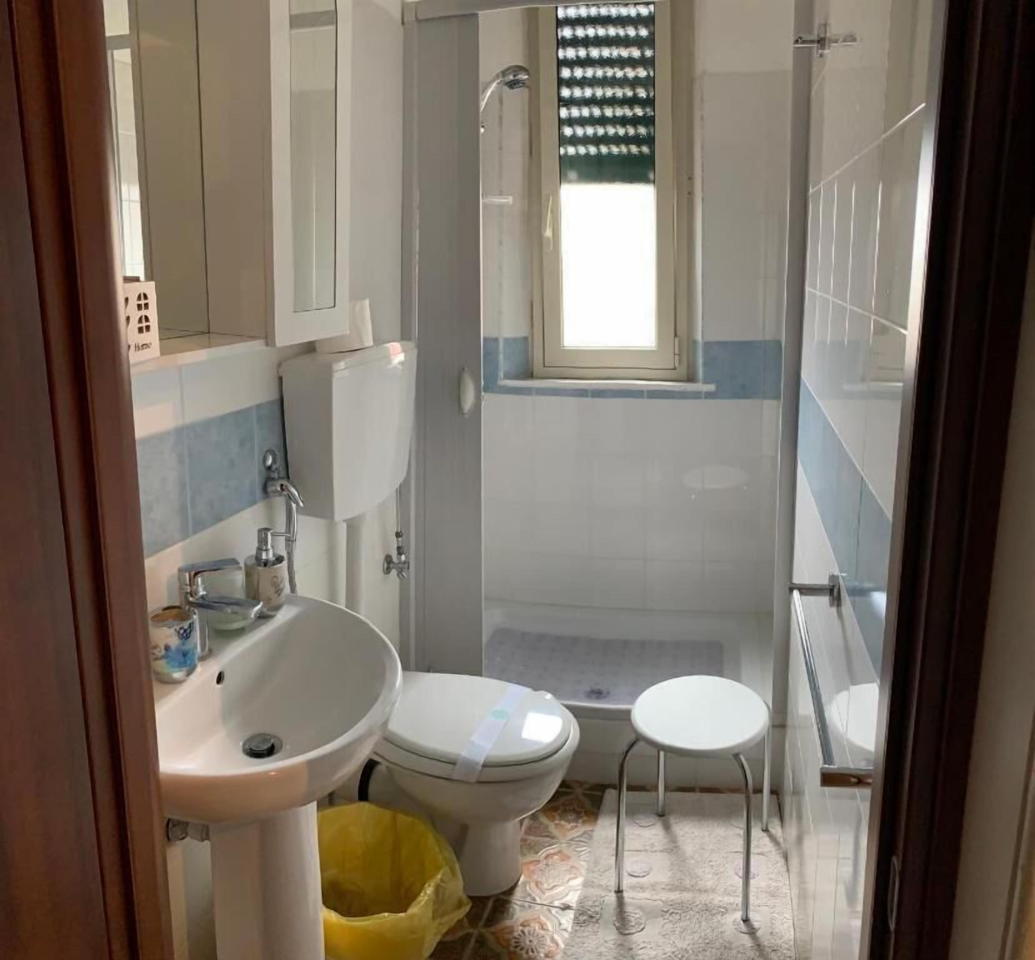 A bathroom with a toilet, sink, and shower.