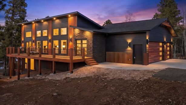 A modern two-story house with a deck, large windows, and a garage. - Hilltop Luxury with Terry Peak Views, Resort Amenities & Year-Round Pool (Lead)