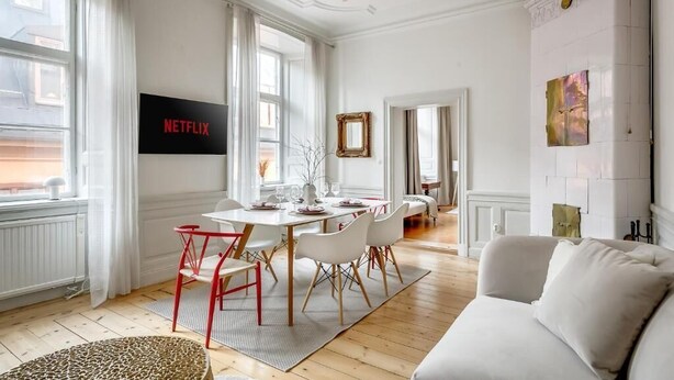 A modern living room with a dining area, a sofa, and a fireplace. - 3BR in Gamla Stan by the Royal Palace (Stockholm)