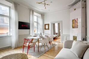 A modern living room with a dining area, a sofa, and a fireplace. - Central 3-bedroom apartment next to the Royal Palace and the Old Town (Stockholm)
