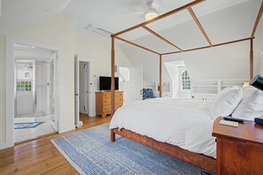 A bedroom with a four-poster bed, a wooden dresser, a television, and a walk-in closet. - Timeless charm at this unique waterfront compound, sleeping 8. (West Dennis)