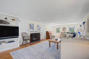 A living room with a television, fireplace, sofa, and coffee table. - Timeless charm at this unique waterfront compound, sleeping 8. (West Dennis)