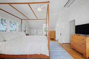 A bedroom with a four-poster bed, a wooden dresser, a television, and a walk-in closet. - Timeless charm at this unique waterfront compound, sleeping 8. (West Dennis)