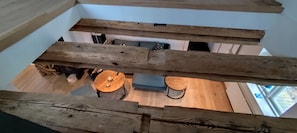 Ein Zimmer mit Holzboden, einem runden Holztisch und einem blauen Stuhl.