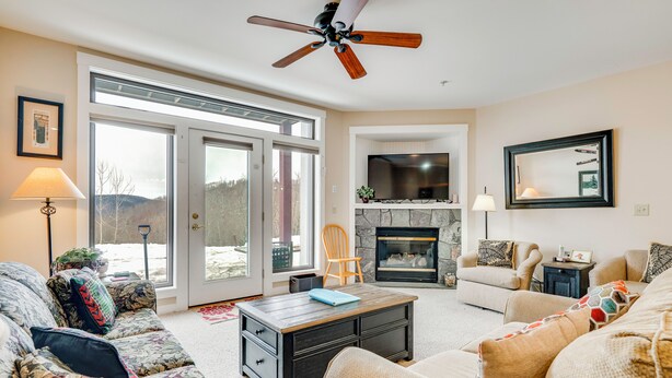 A living room with a fireplace, sofa, coffee table, and a television. - Direct Trail Access: Resort-style Killington Gem (Killington)