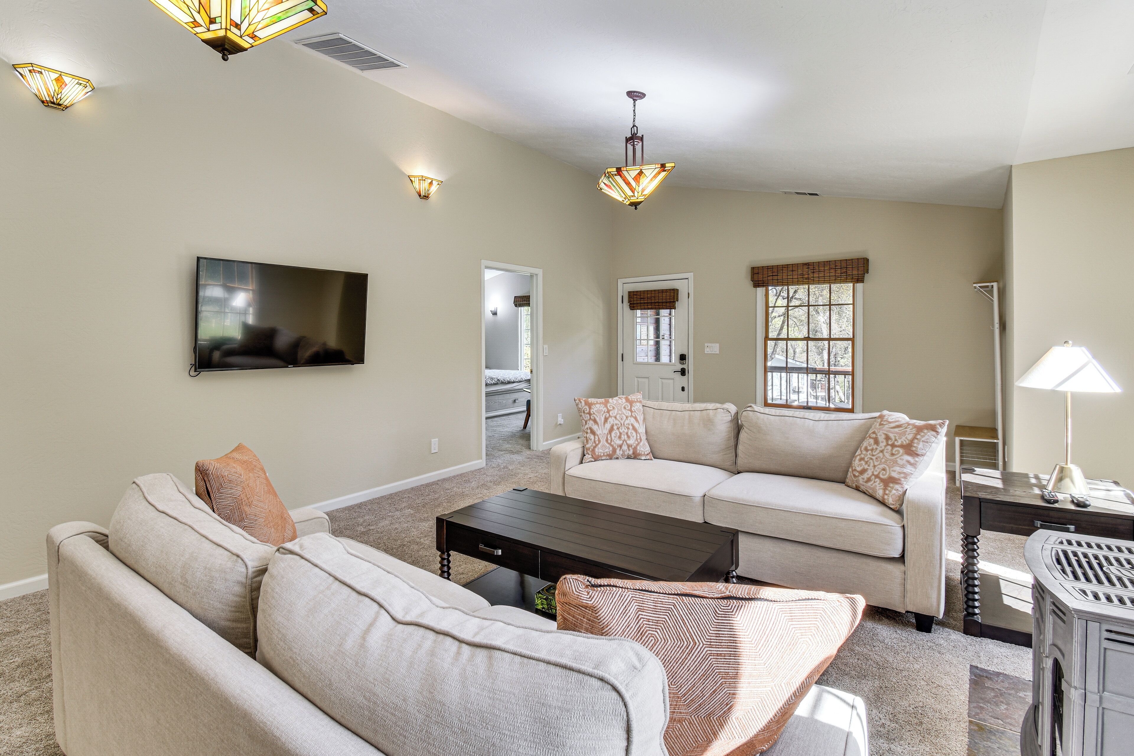 A living room with a sofa, a coffee table, a TV, and a fireplace.