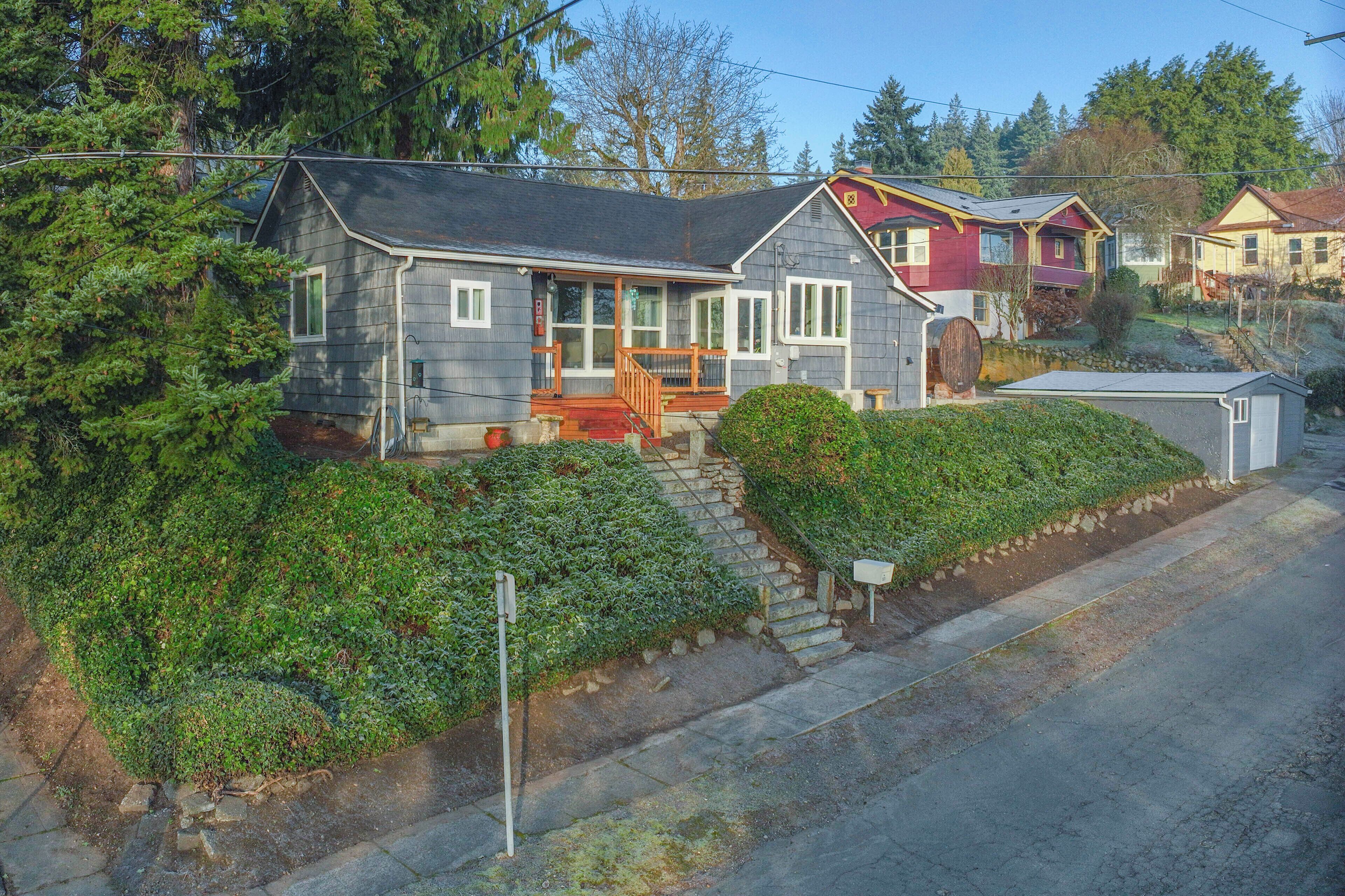 A two-story house with a porch, a garage, and a driveway.