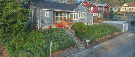 A two-story house with a porch, a garage, and a driveway.