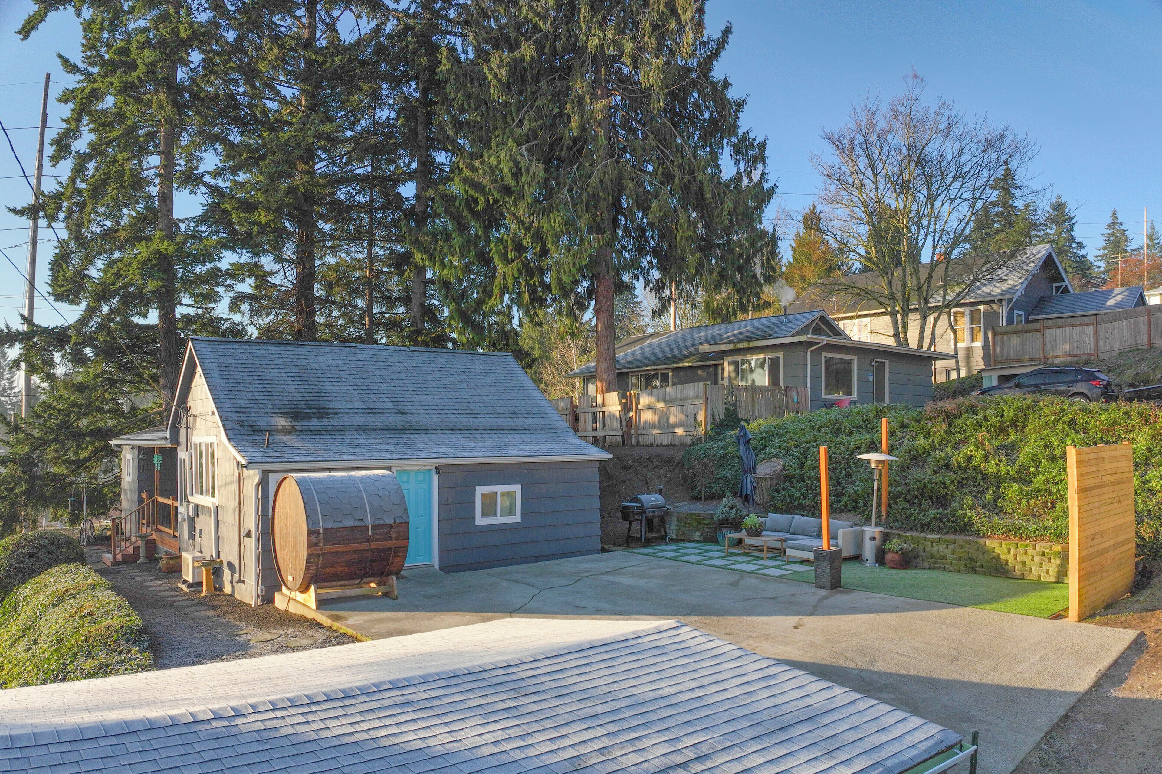 A residential property with a detached house, a small shed, and a covered outdoor area with a barbecue.