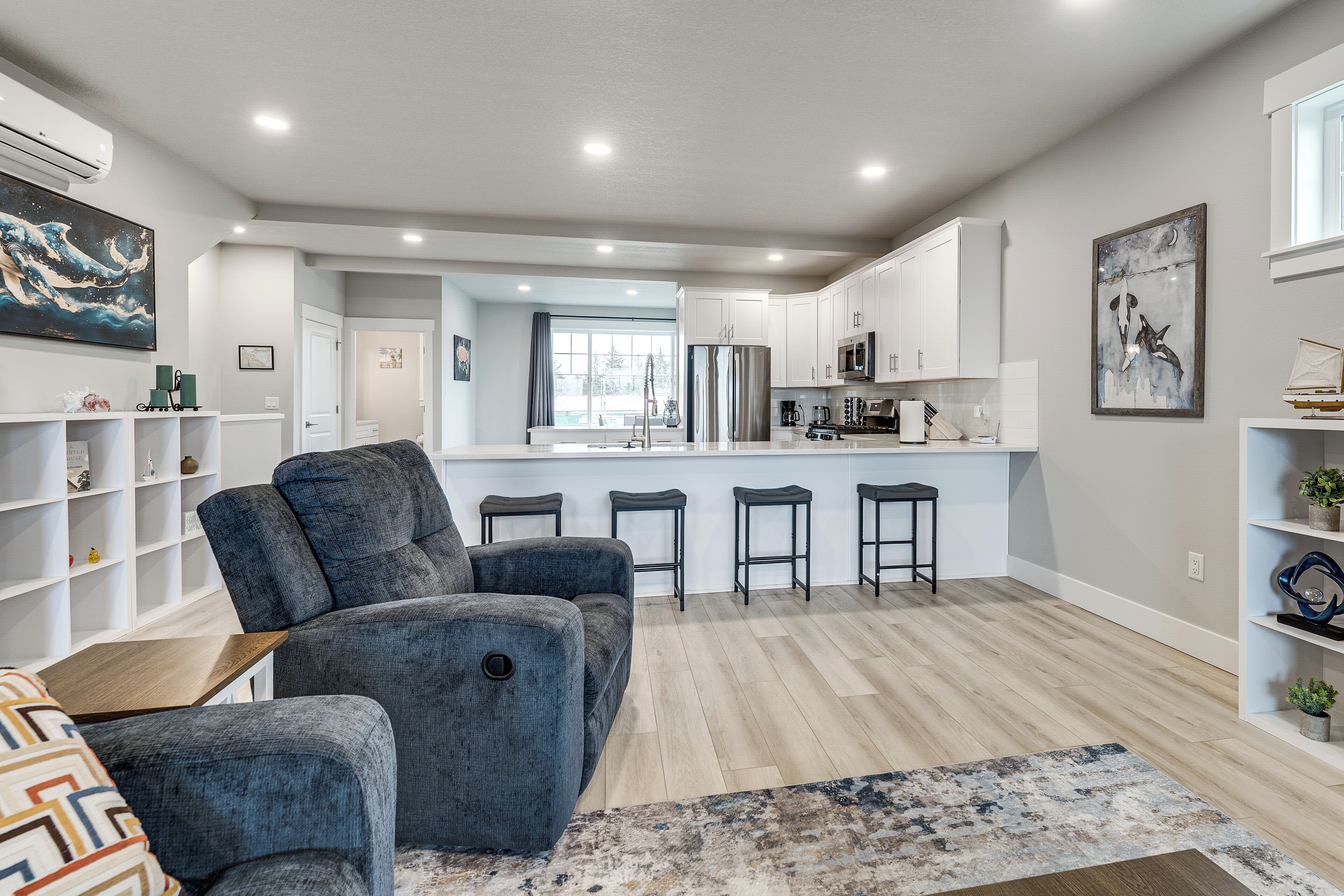 A modern kitchen with white cabinets, a central island, and a bar area.