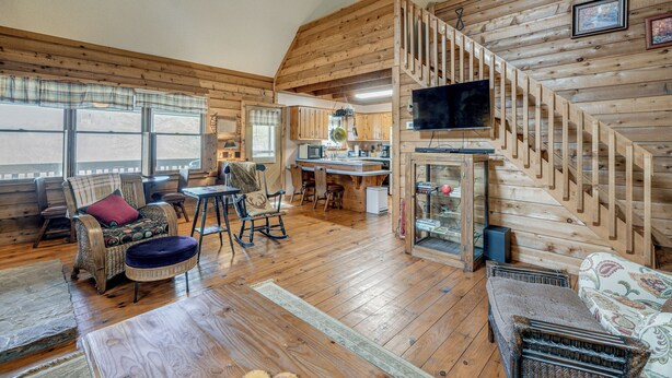 L’intérieur d’une cabane comprend un coin repas, une cuisine et un escalier menant à une mezzanine.