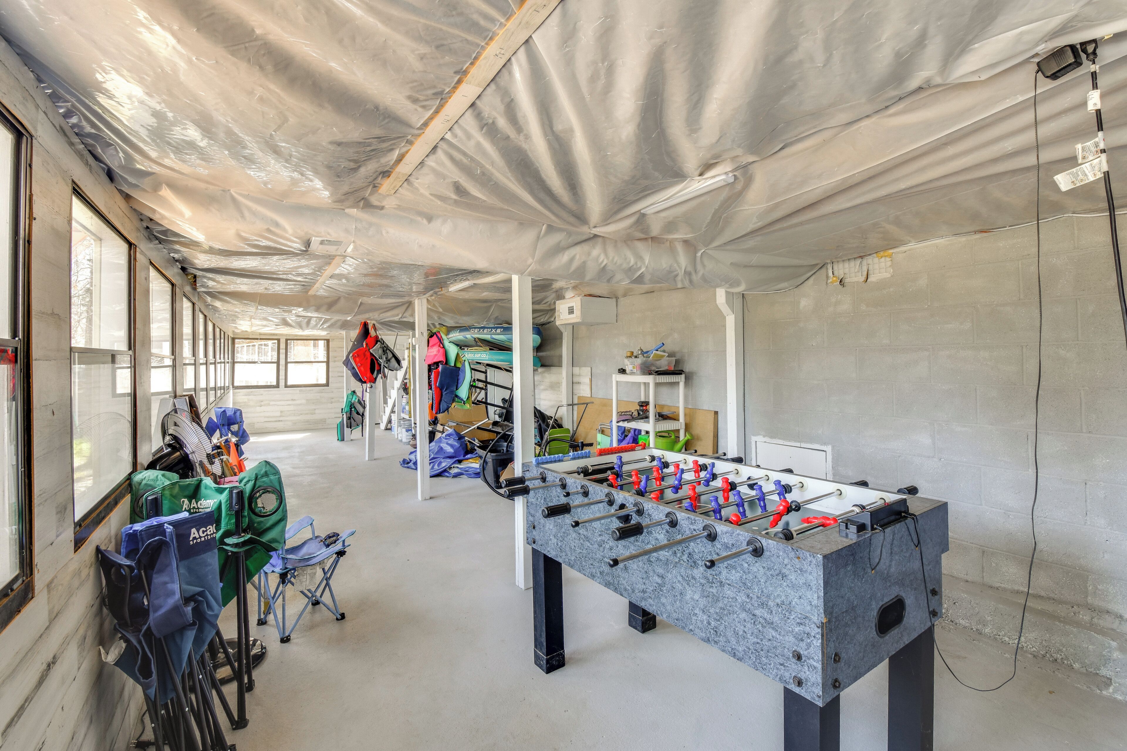 Une pièce avec une table de baby-foot, une fenêtre et une chaise.