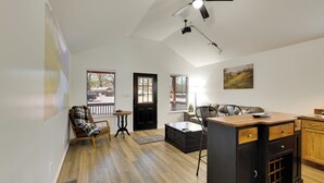 A spacious living area with a ceiling fan, a dining table, a sofa, and a kitchen counter. - 3 Mi to Boat Ramp! Tiny Cabin Near Sabine River (Joaquin)