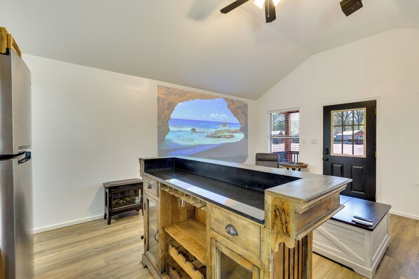 A kitchen with a wooden island, a refrigerator, and a door with a window.