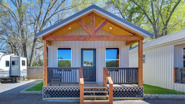 A small wooden cabin with a porch, a front door, and two windows. - Piney Woods Tiny Cabin: 3 Mi to Sabine River! (Joaquin)
