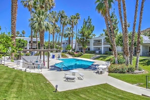 A swimming pool surrounded by palm trees and a patio area with outdoor furniture. - 5 Mi to Dtwn! Extended-stay Palm Springs Condo (Palm Springs)