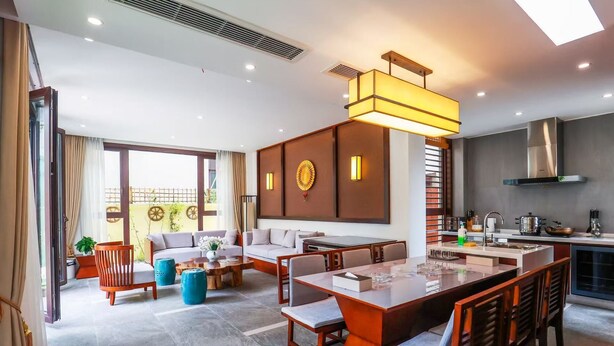 A modern hotel room with a dining area, a kitchen, and a balcony with a view. - Book and Bed-Chong Ming (Shanghai)