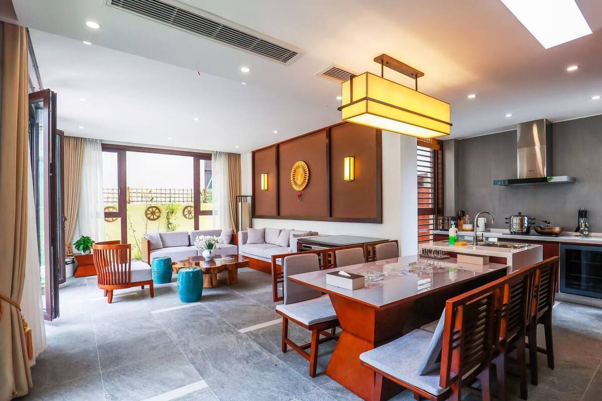 Une chambre d’hôtel moderne dotée d’un coin repas, d’une cuisine et d’un balcon avec vue.