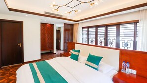 A hotel room with a large bed, a wooden headboard, a chandelier, a wardrobe, and a window with a view. - Book and Bed-Chong Ming (Shanghai)