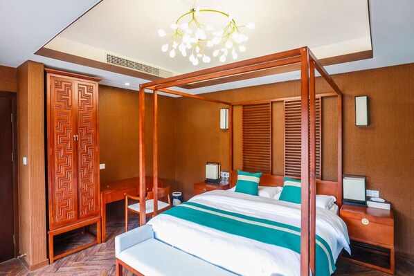 Un lit à baldaquin, une armoire en bois, un bureau avec une chaise et une table de chevet avec une lampe.