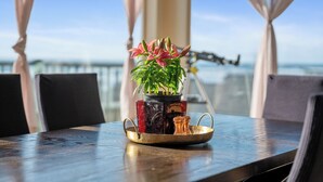 Et bord med en potteplante, saltshaker og et glas med drik.