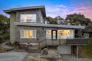 Ein modernes, zweistöckiges Haus mit überdachter Veranda, Garage und gepflegtem Vorgarten.