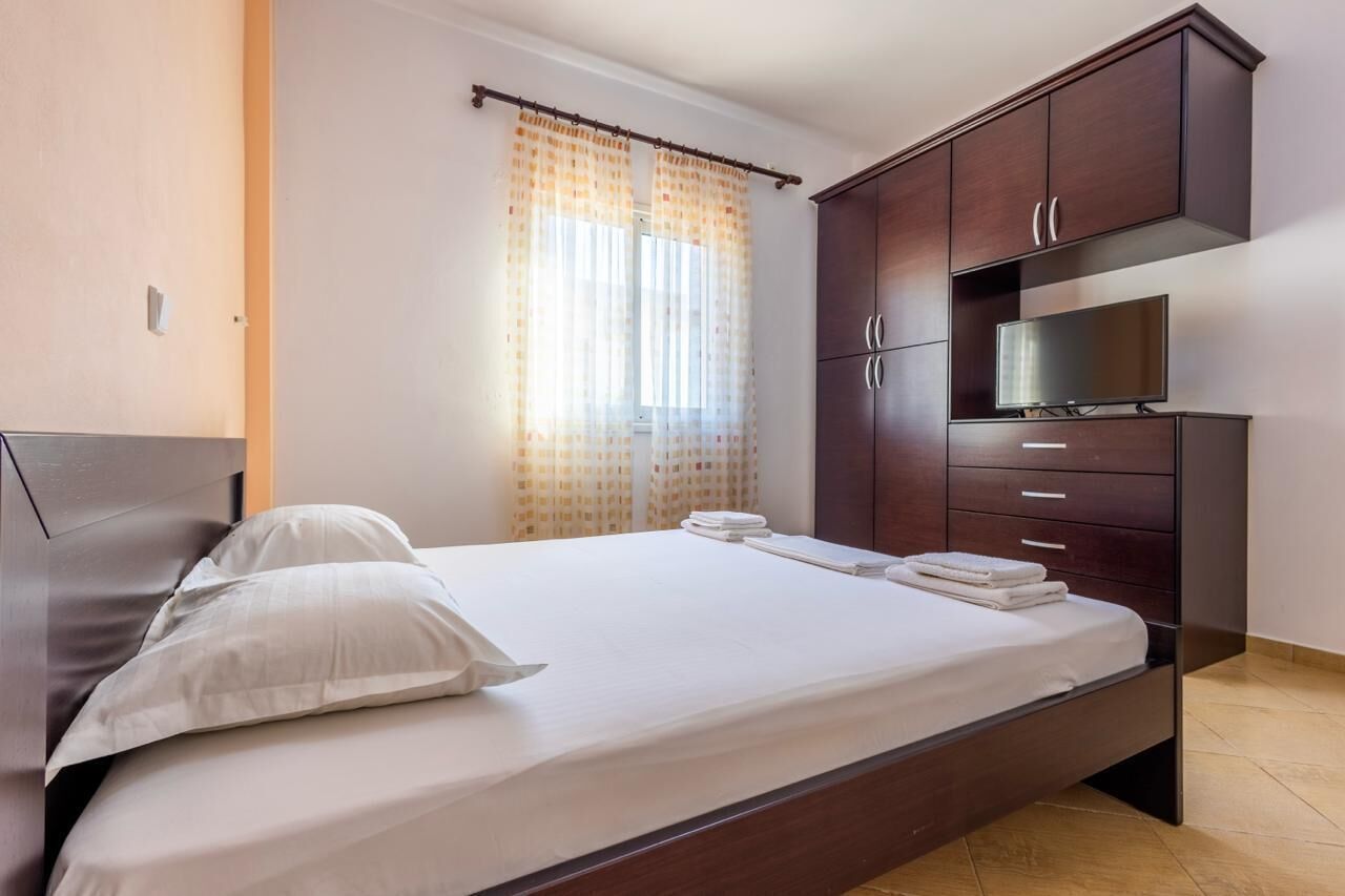 A bedroom with a bed, a TV, and a wardrobe.