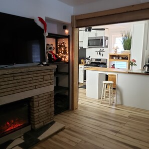 Cozinha moderna com lareira, micro-ondas e área de jantar com um banquinho de bar.