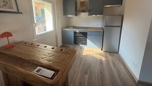 Una cocina moderna con vigas de madera, una ventana y una mesa con un dispositivo encima.