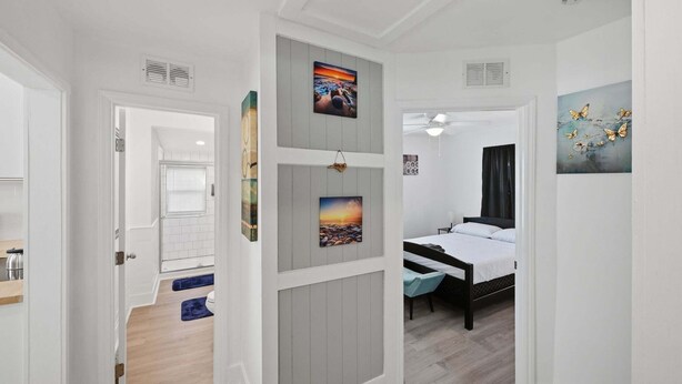 A bedroom with a bed, a bedside table, a window, and a door leading to another room. - Peaceful Stay Near Wake Forest 2 Bedroom Home (Franklinton)