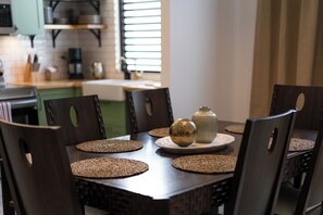 Una mesa de comedor con individuales, dos jarrones decorativos y un plato.