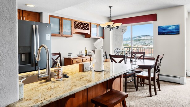 A modern kitchen with granite countertops, stainless steel appliances, and wooden cabinetry. - Mountain Escape in Frisco | 2BR w/ Shared Hot Tub (Frisco)