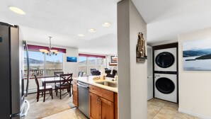 A kitchen with wooden cabinets, a dining table, and a built-in washer and dryer. - Mountain Escape in Frisco | 2BR w/ Shared Hot Tub (Frisco)